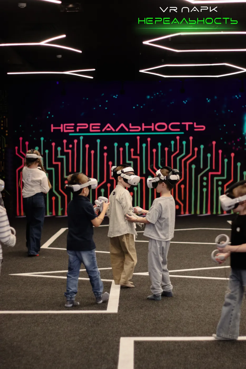 Класс играет на VR-арене под неоновой вывеской парка