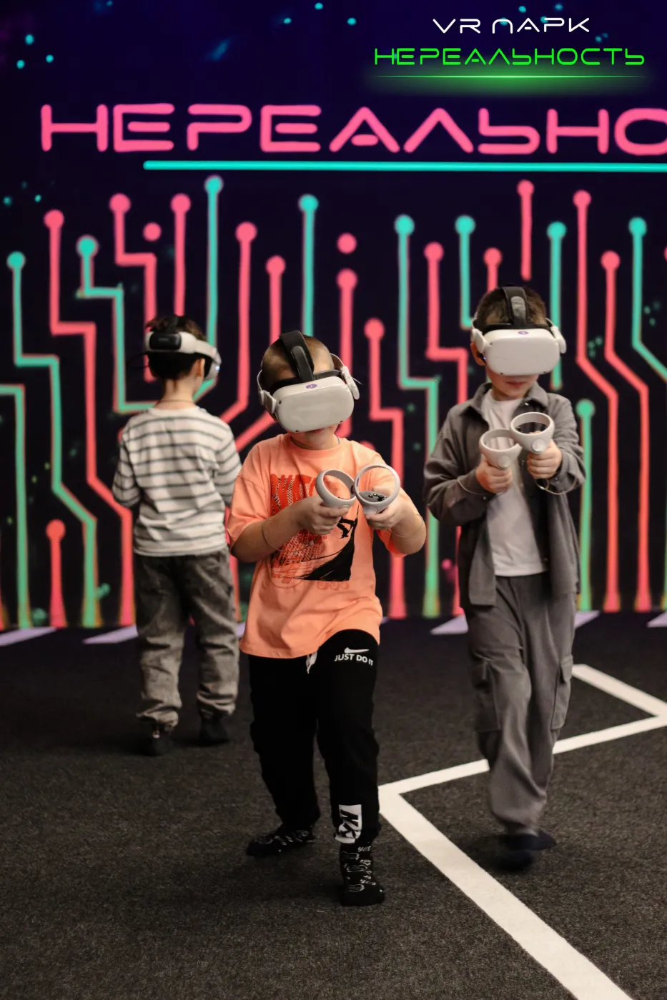 Дети в VR-шлемах играют на арене парка