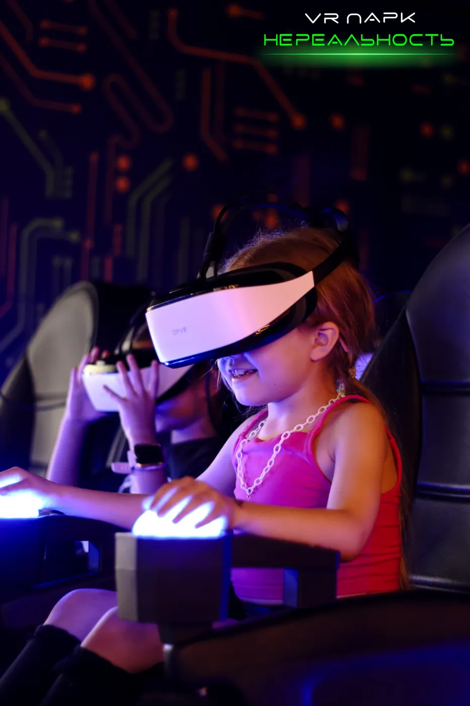 Девочка в VR-шлеме на аттракционе-кресле